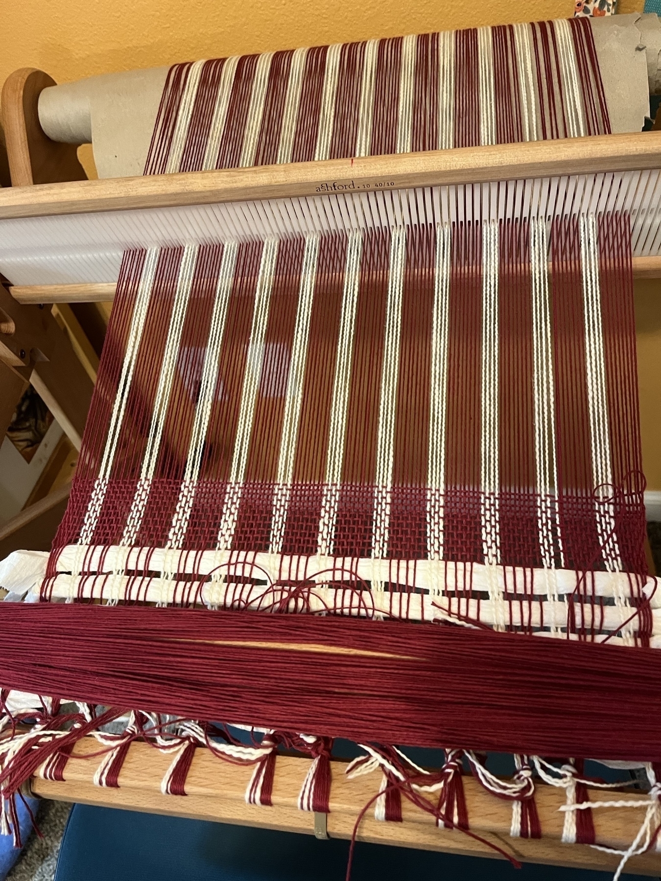 red and white yarn warped on a rigid heddle loom